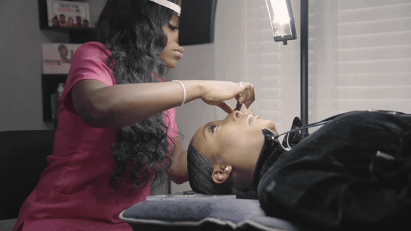 Black girl doing eyelash extensions gif